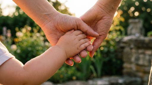 A parent holding a small child's hand outdoors